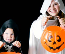 big sister and little brother dressed up for a Halloween smiling