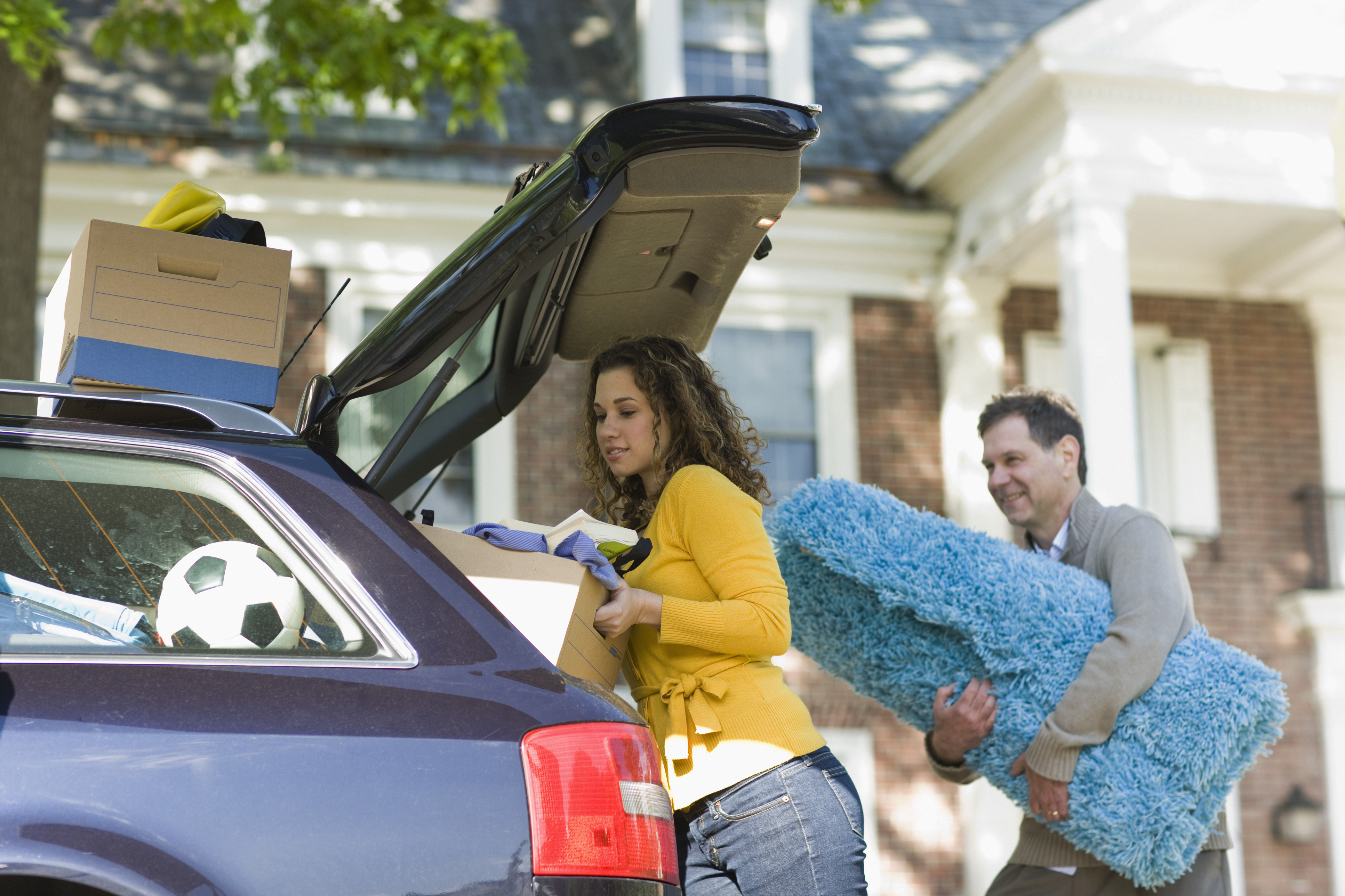 parents putting their child's belonging in car