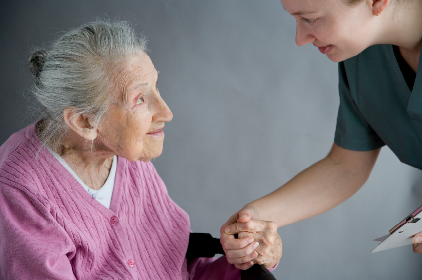 elderly woman is getting help from a nurse